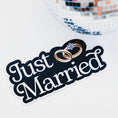 Load image into Gallery viewer, Decorative sign with 'Just Married' text and wedding rings, next to a disco ball on a white background.