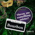 Load image into Gallery viewer, Decorative elements with a mask, beads, and street sign on a green glittery background.