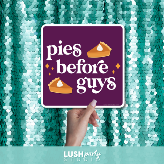 Hand holding a prop sign with 'pies before guys' by lush party studio