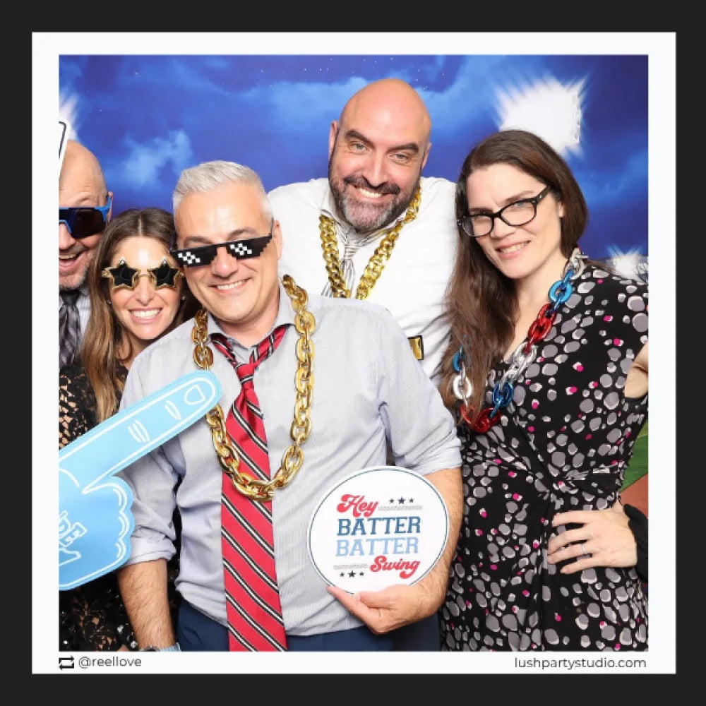 Group of people posing with baseball props in a photo booth 