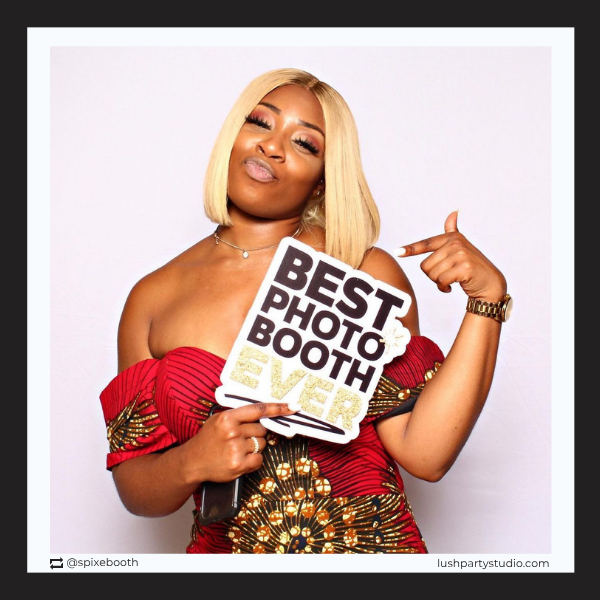 Woman holding a sign that says 'Best Photo Booth Ever' by lush party studio