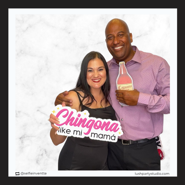 Two people holding a chingona prop sign by lush partys tudio