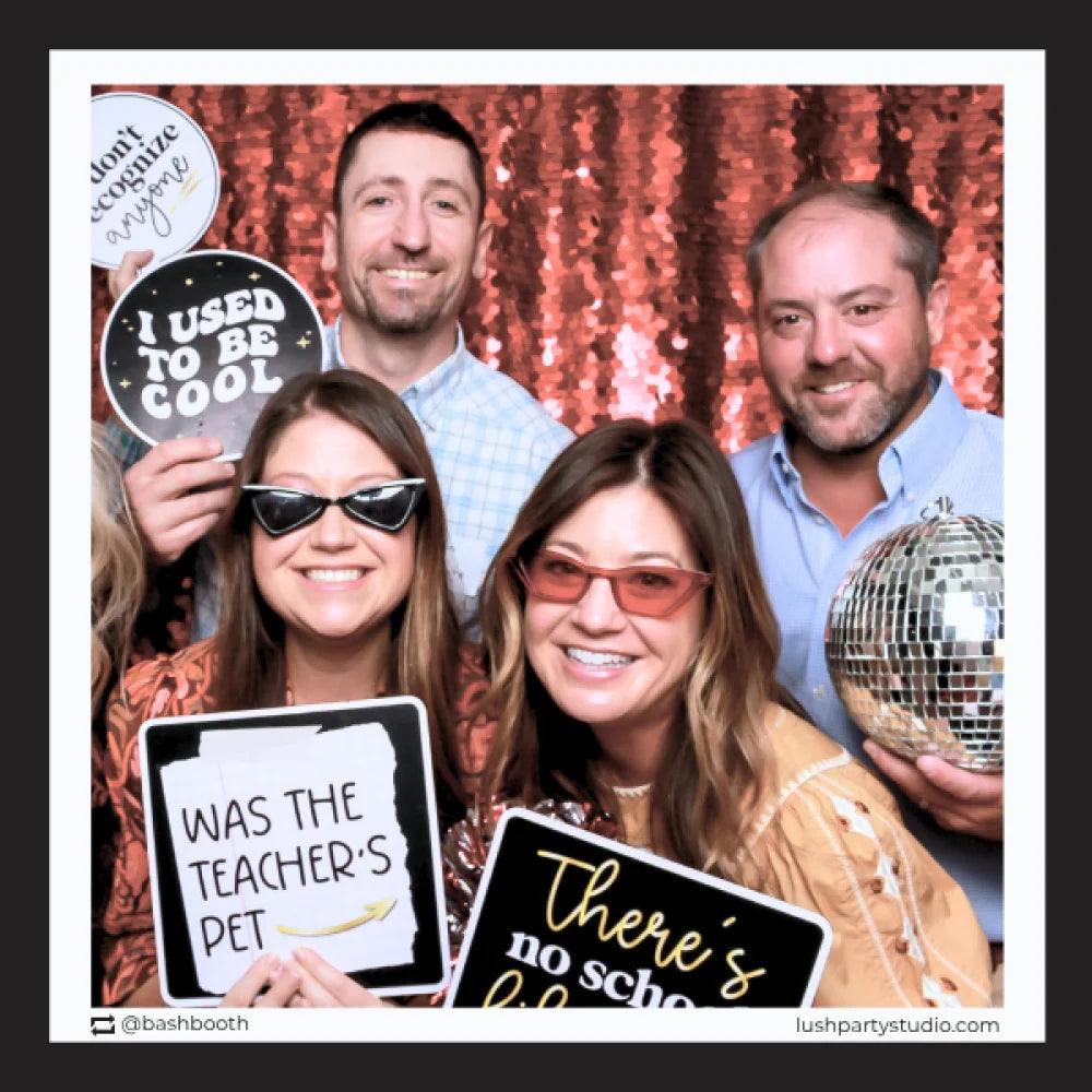 Group of people posing with class reunion photo booth props by lush party studio