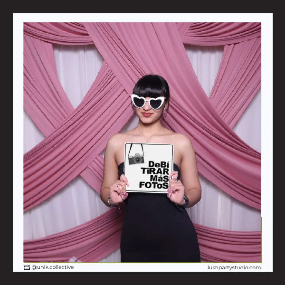 Woman holding a sign with pink curtains in the background