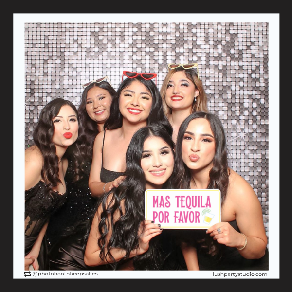 Group of women posing with a fiesta prop sign with mas tequila por favor text