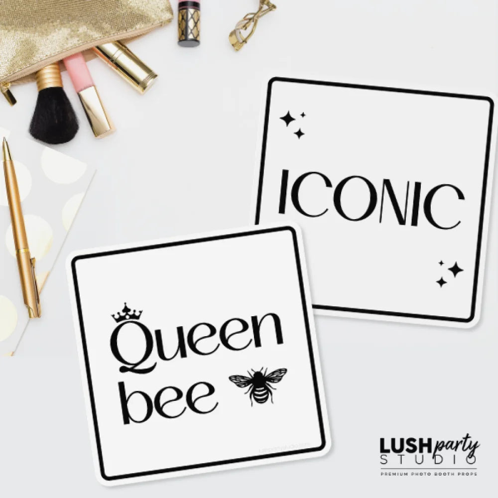Two black and white photo booth prop signs with 'Queen bee' and 'Iconic' text by lush party studio