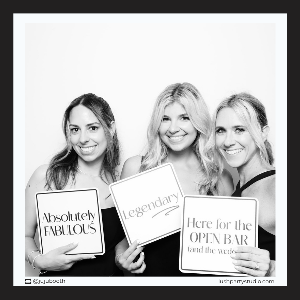 photo booth prop signs with party phrases in a black and white photo 