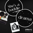 Load image into Gallery viewer, Black background with 'She's a baddie' and 'drama' text, Polaroid camera, and photo of a person holding a book.
