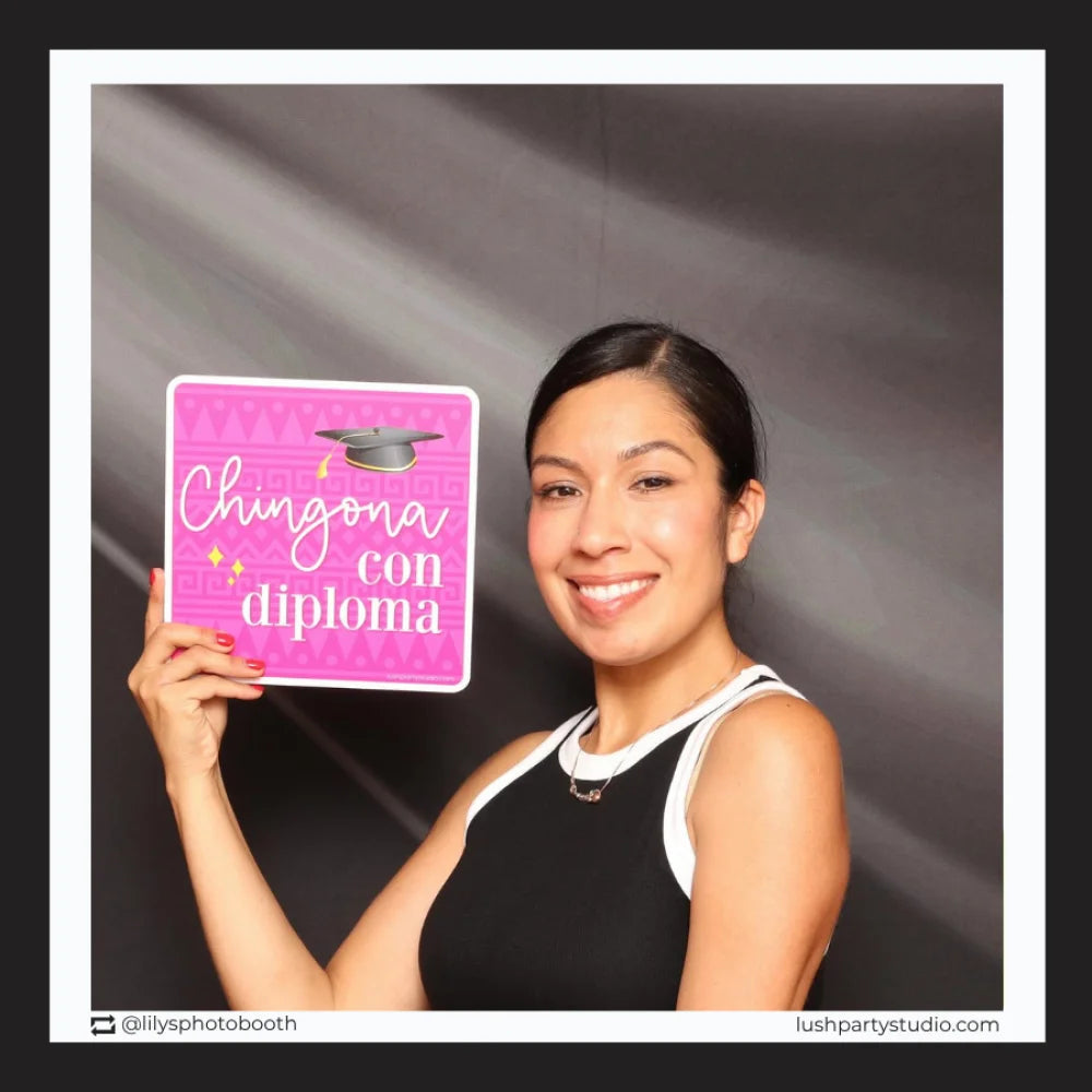 Woman holding a sign with 'Chingona con diploma' photo booth prop signs for graduacion