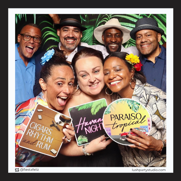 Group of people posing withhavana nights  signs in a photo booth 