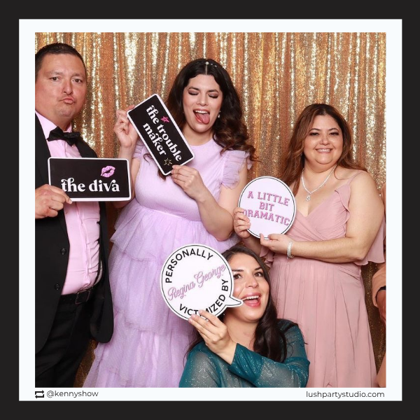 Group of people posing with mean girls photo booth signs by lush party studio
