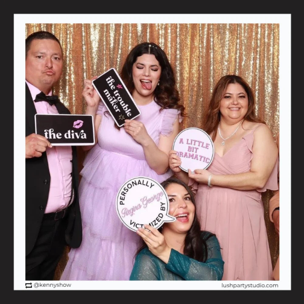 Group of people posing with mean girls photo booth signs by lush party studio