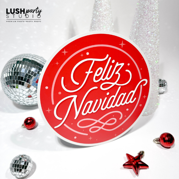 photobooth prop with 'Feliz Navidad' text surrounded by Christmas ornaments on a white background.