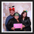 Load image into Gallery viewer, Three people posing with festive hats and glasses in a photo booth with a 'Navidad en familia' christmas prop sign.
