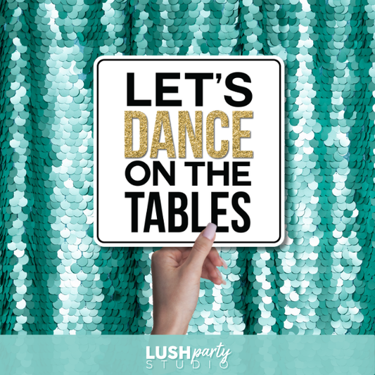 photo prop sign with 'Let's Dance on the Tables' text by Lush Party Studio logo.