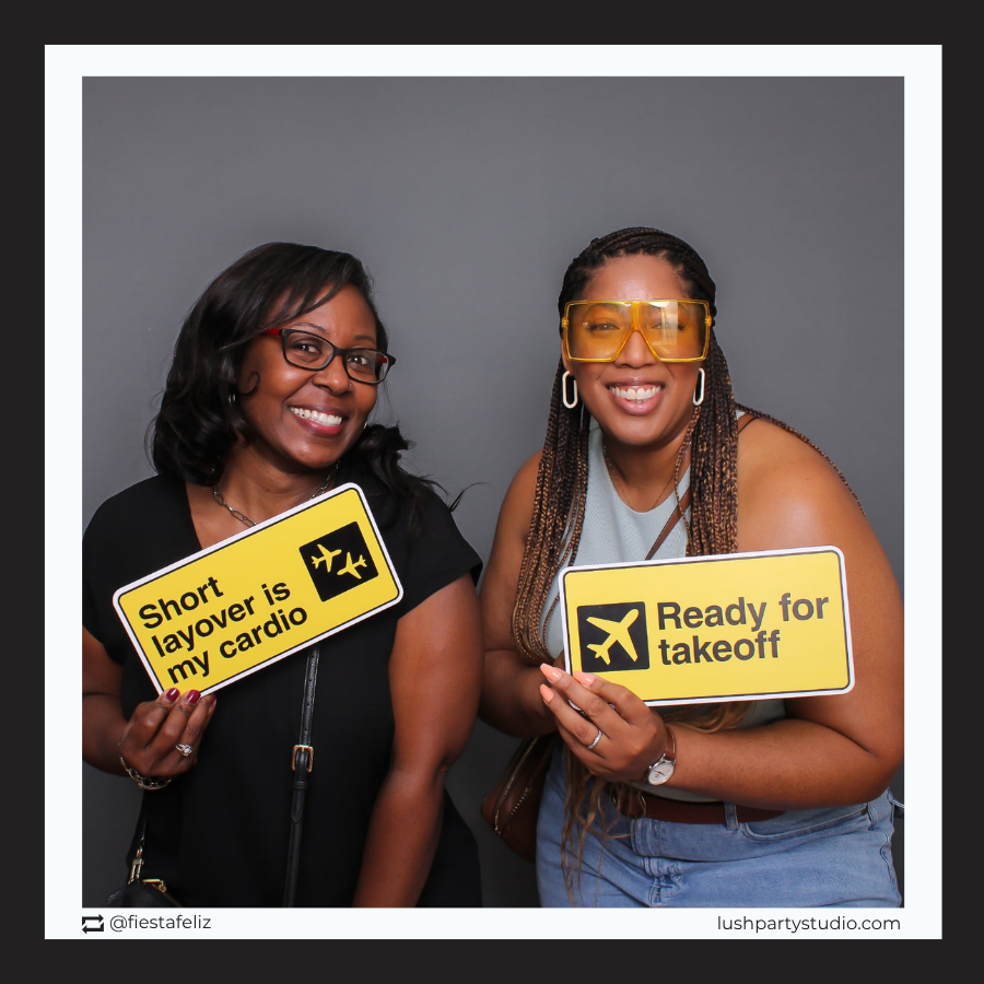 people posing with travel themed photo booth prop signs by lush party studio