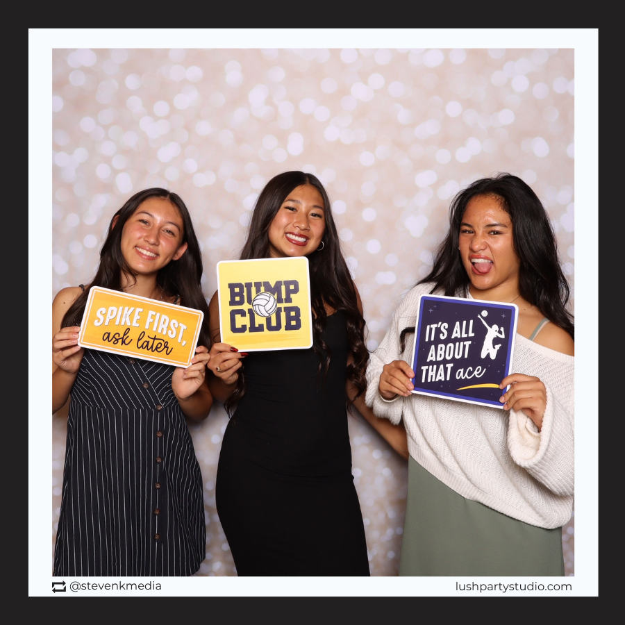 Three women holding volleyball prop signs by lush party studio