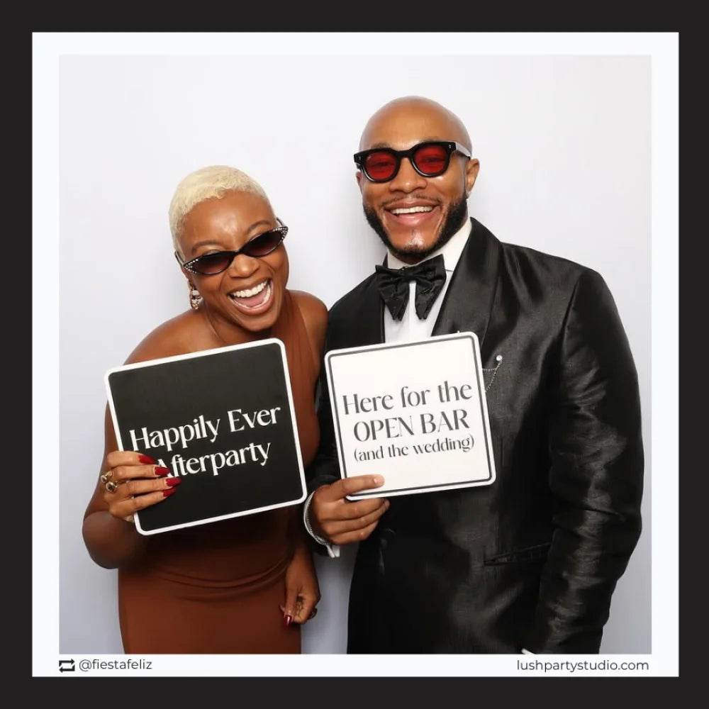 Two people posing with wedding photo booth prop signs in a photo booth, glam vogue wedding props by lush party studio