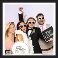 Load image into Gallery viewer, Group of people in formal attire with 'The Bride' and 'The Groom' photo booth prop signs, at a photobooth. 
